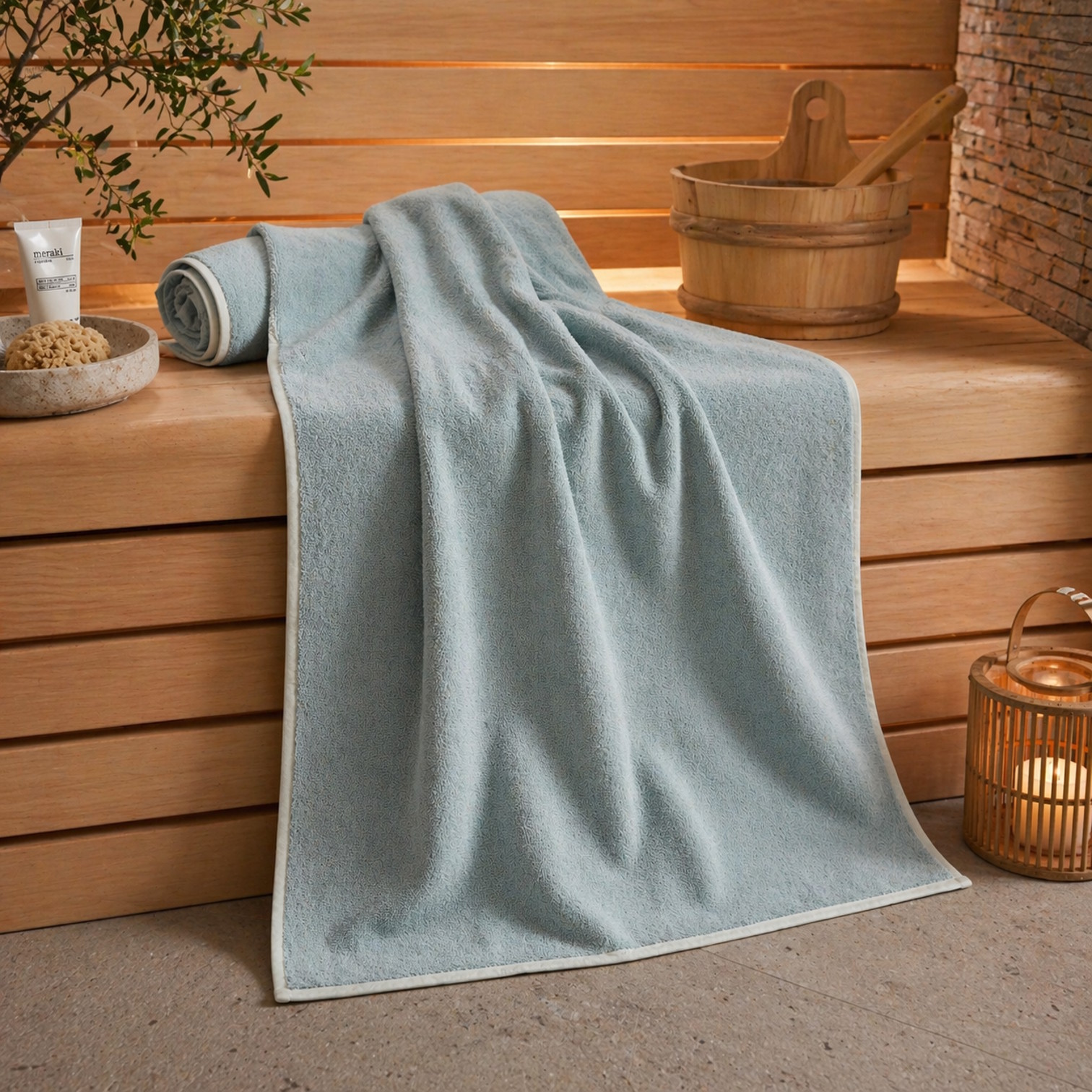 MARC O'POLO Timeless Melange Saunatuch in Aquamarine auf Holzbank in Sauna mit natürlichen Accessoires