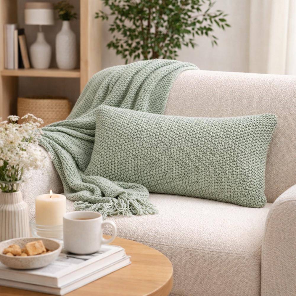 Marc O Polo Dekokissen Nordic Knit Garden Green auf Sofa im Wohnzimmer mit Strickdecke und natürlichen Wohnaccessoires im skandinavischen Stil