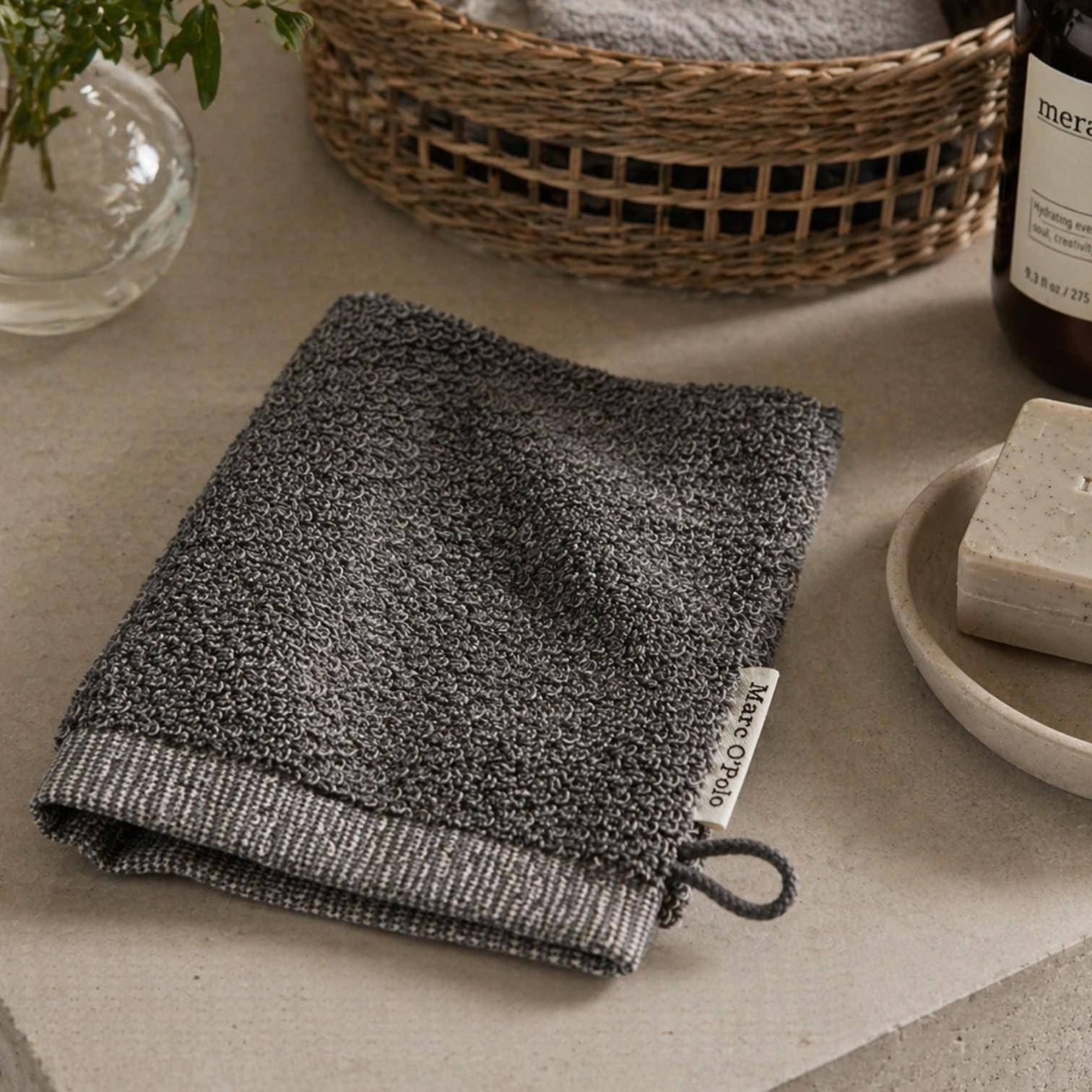 MARC O'POLO Timeless Melange Waschhandschuh in Anthrazit im Badezimmer mit Seife und Accessoires dekoriert